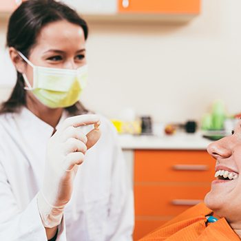 Dentist in Hampton showing tooth to smiling patient