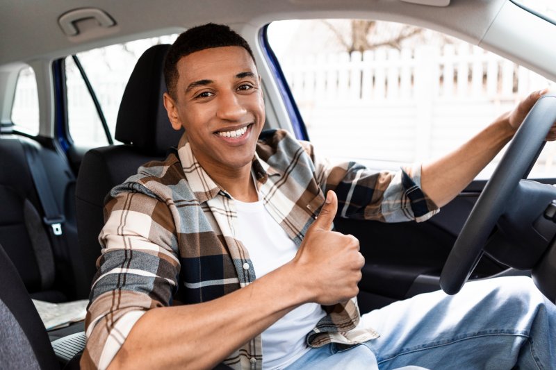 Man smiles in car